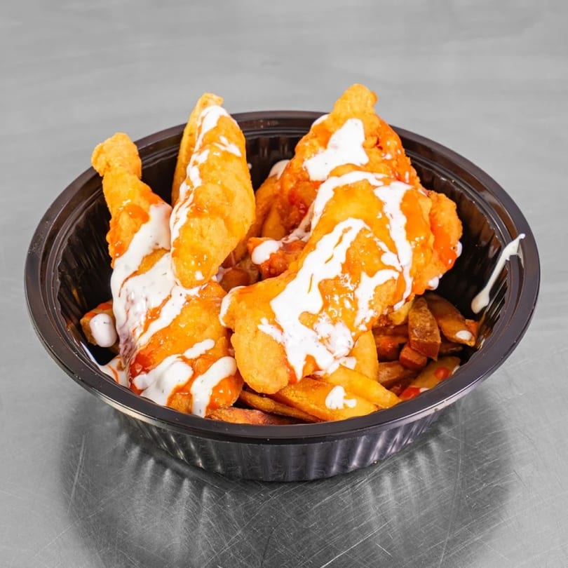 Burritos & Bowls' buffalo chicken tenders and fries, drizzled with ranch, in a black bowl.